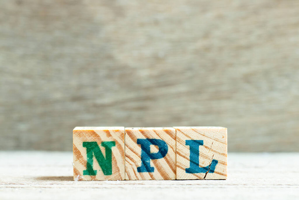 Letra alfabética em palavra NPL (Abbbreviation of Non Performing Loan, Literatura Não Patente) sobre fundo de madeira
 - Foto, Imagem