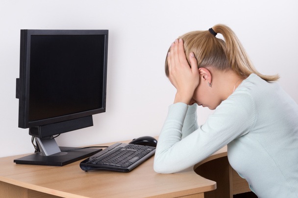 Achteraanzicht van gestresst vrouw met personal computer op het werk - Foto, afbeelding