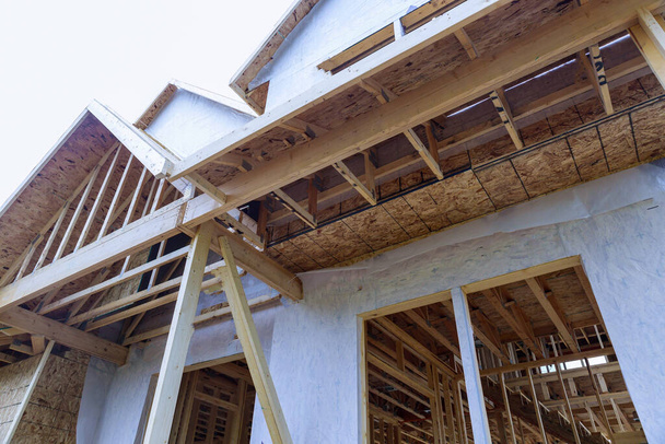 Στέγη δομή του σπιτιού πλαισιώνει μια ενιαία οικογένεια υπό κατασκευή - Φωτογραφία, εικόνα