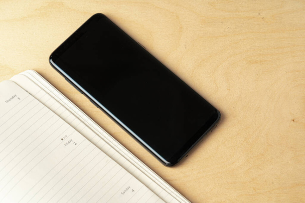 Malli tyhjän käyntikortin ja musta älypuhelin näyttö pöydällä - Valokuva, kuva