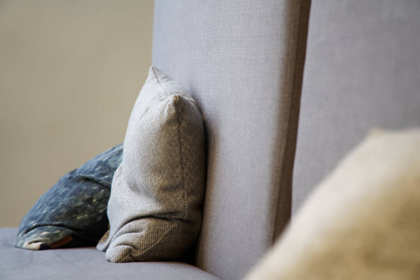 Almohadas beige en sofá de lona, fondo de enfoque suave
. - Foto, imagen