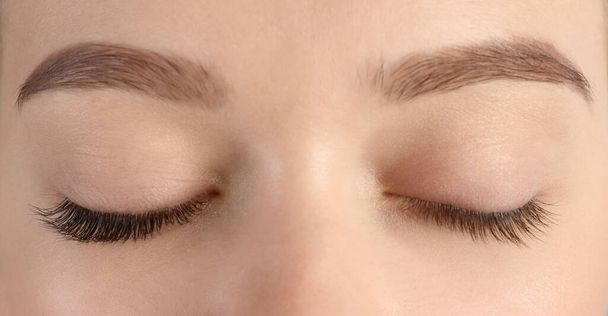Young woman with beautiful eyelashes, closeup. Before and after extension procedure - Photo, Image