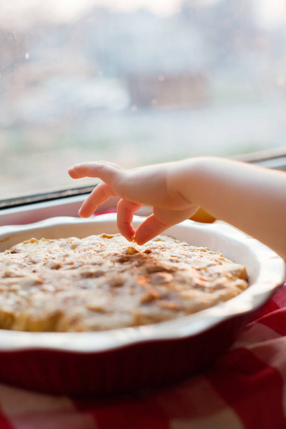 Childs ruka dotknout čerstvé pečené jablečný koláč - Fotografie, Obrázek