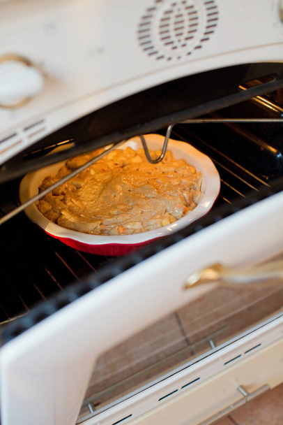 Apfelkuchenbacken im Ofen. Backkonzept, Apfelkuchen backen - Foto, Bild