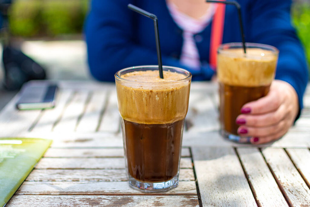 Traditional greek cold coffee Frappe with foam made from water, instant coffee and ice cubes in glass close up - Photo, Image