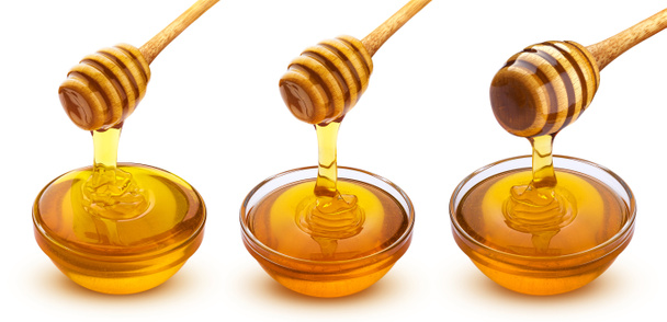 Med tyčinka a miska nalévání medu izolované na bílém pozadí s výstřižkem cesta, máčecí s tekoucím cukerným sirupem - Fotografie, Obrázek