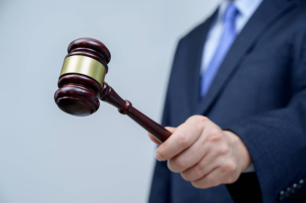 Male businessman holding a gavel in hand. justice and auction concept. - Photo, Image