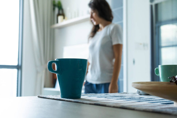 Morning mug of coffee on the table on the background of a girl - Фото, зображення