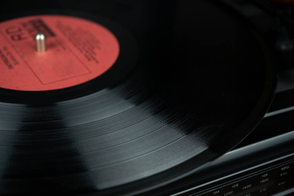 Close-up van vintage vinyl met rood label op een speler - Foto, afbeelding