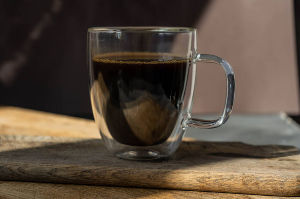café negro en taza grande transparente sobre fondo negro
 - Foto, imagen