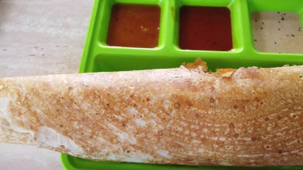 VPO de um homem a comer thosai. Uma dosa (thosai, tosai) é um tipo de panqueca ou crepe, originário do subcontinente indiano, feito de uma massa fermentada, geralmente vem com curry e dhal e chutney.
 - Filmagem, Vídeo