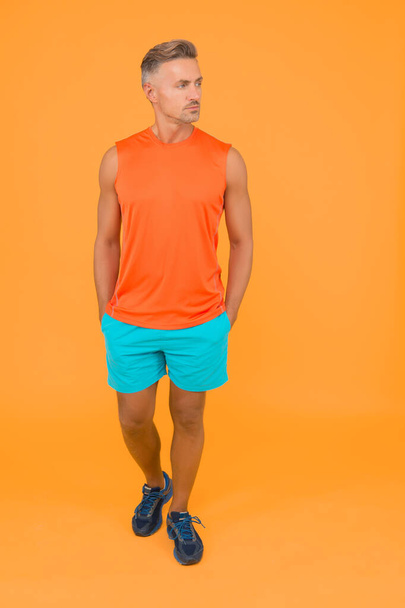 Seems like very confident and handsome. Confident sportsman orange background. Confident look of muscular guy. Athletic type. Feeling confident and cool. Every workout is progress - Foto, Bild