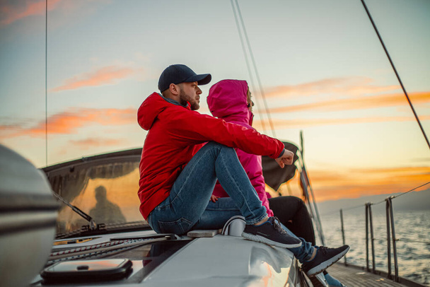 Glückliche Eheleute ruhen sich bei sonnigem Tag auf Jacht aus - Foto, Bild