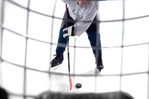 Unrecognizable male hockey player with the stick on ice court and white background - Foto, Imagen