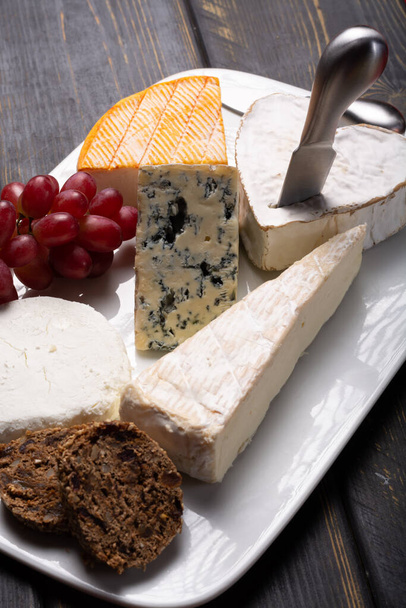 Prato de queijos franceses em sortimento, queijo azul, brie, munster, queijo de cabra macio, queijo em forma de coração Neufchatel
 - Foto, Imagem