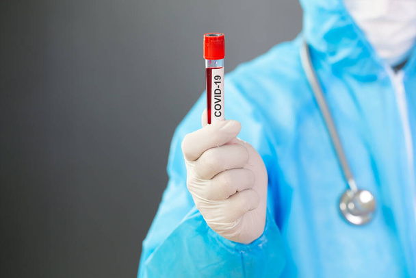 Cientista Médico vestindo EPI e segurando sangue de pessoa infectada covid-19 para pesquisa de vacinas prevenir ou tratar o novo coronavírus SARS-CoV-2, Médico-cientista ou conceito de médico de pesquisa
 - Foto, Imagem