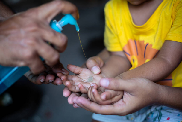 子供は液体洗浄ゲルで手をきれいにする方法を学んでいます。コロナウイルスを防ぐために、石鹸で手をこすりますコロナウイルスの拡散を停止するための専門家の方法です。. - 写真・画像