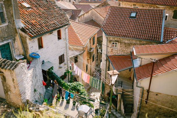 Kleidung wird an einem Seil getrocknet, zwischen Gebäuden in der Altstadt von Kotor, Montenegro. - Foto, Bild