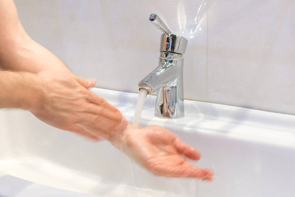 浴室のシンクに石鹸で手を洗う若い白人男性の閉鎖個人的な衛生、ウイルスや細菌の概念に対する保護. - 写真・画像
