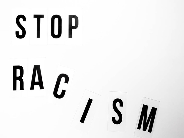 Noirs vit matière concept. Lettres majuscules avec le texte arrêter le racisme sur fond blanc - Photo, image