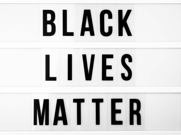 Zwarte levens materie concept. Lichtbak met de tekst "black lives matter" tegen zwart-witte achtergrond - Foto, afbeelding