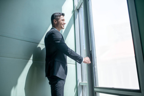 Man in a suit standing near the window - 写真・画像