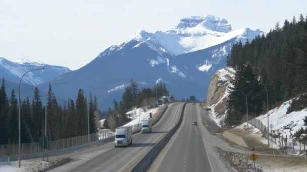 Двоє вантажних автомобілів їдуть по Транс - Канада шосе в сонячний зимовий день.. - Кадри, відео
