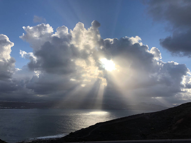 Sol brillando a través de las nubes alrededor de Las Palmas, Gran Canaria
 - Foto, Imagen
