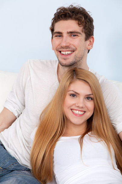 Young beautiful couple on a sofa at home - Fotoğraf, Görsel