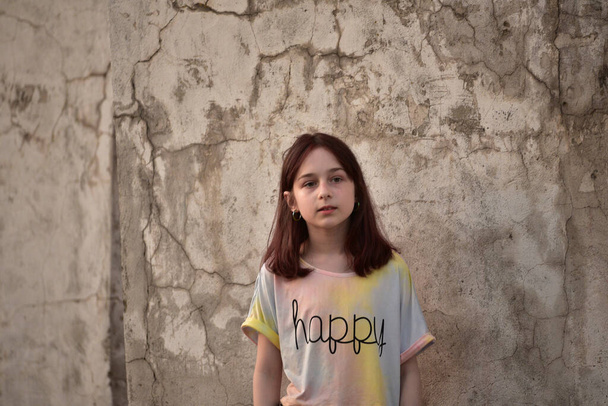 Εννιάχρονο κορίτσι το καλοκαίρι. Έφηβη με ελαφρύ μπλουζάκι με σοβαρή έκφραση στο πρόσωπό της. Ένα συναίσθημα σοβαρότητας και στοχασμού. Έφηβος με προσοχή. - Φωτογραφία, εικόνα