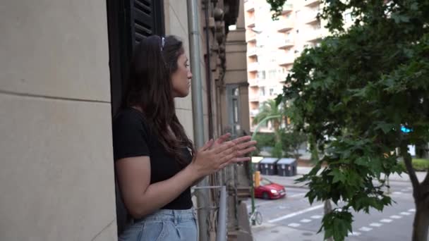 İspanyol genç kız Covid 19 'a karşı İspanyol sağlık hizmetlerini desteklemek için dairesinin balkonundan alkışlıyor. - Video, Çekim