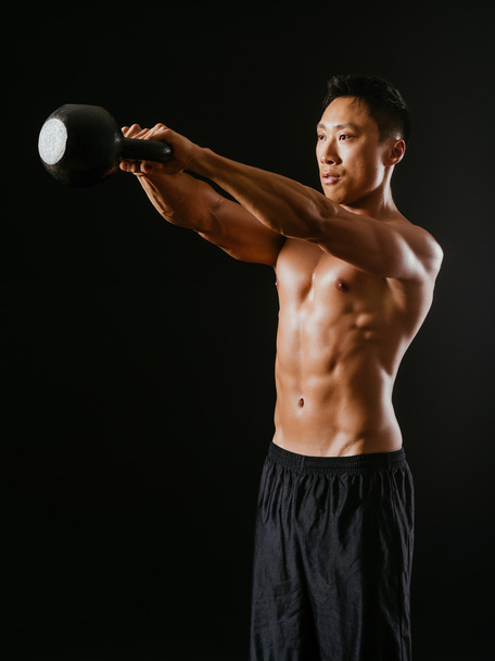 Muscular man working out with kettle bell - Foto, afbeelding