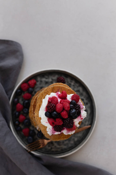 Topview image of oatmeal pancakes topped with yogurt and berries - Photo, Image