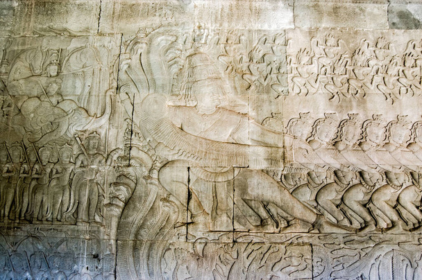 Tallado jemer histórico que muestra a los demonios tirando de la serpiente sagrada de múltiples cabezas conocida como Vasuki. La leyenda hindú, el Churning of the Ocean of Milk, Bajorrelieve en el templo de Angkor Wat, Camboya
. - Foto, Imagen