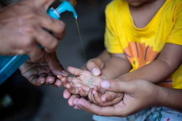 Un niño está aprendiendo a limpiar las manos con gel de limpieza líquido. Para prevenir el coronavirus, frotarse las manos con jabón es una forma experta de detener la propagación del coronavirus.
. - Foto, imagen