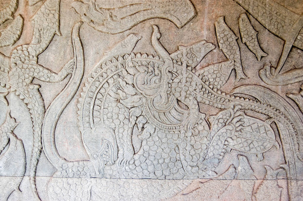 Antiguo Kymer talla de la creación del mundo con Dios luchando contra los demonios Un león chino está luchando contra un cocodrilo. Churning of the Ocean of Milk gallery, Angkor Wat, Siem Reap, Camboya
. - Foto, imagen