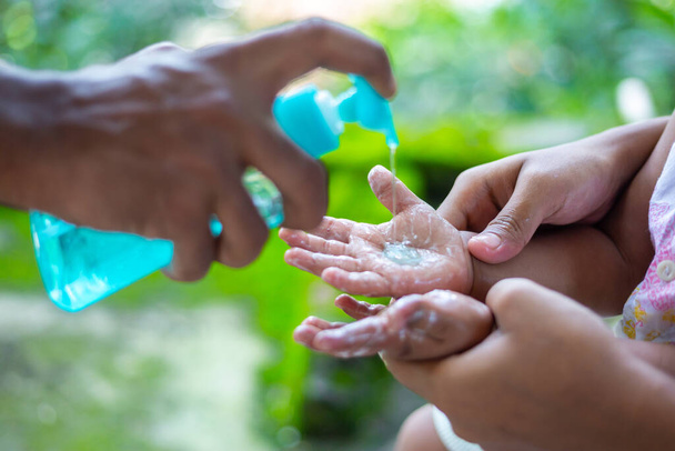 Een ouder leren zijn baby de gewoonte van handwas met vloeibare handwas. Om te voorkomen dat coronavirus, wrijven uw handen met zeep is een deskundige manier om de verspreiding van het coronavirus te stoppen. - Foto, afbeelding