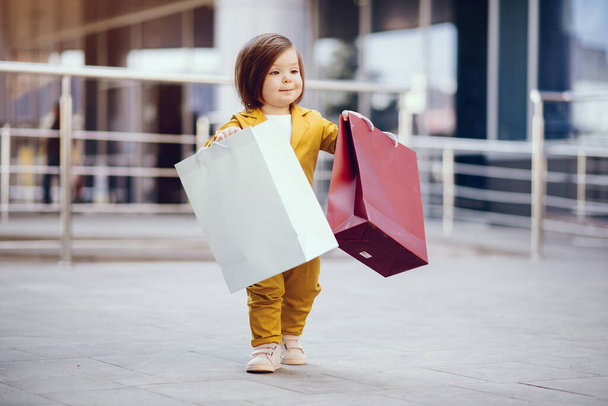 Cute little girl with shopping bag in a city - Fotó, kép