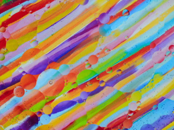 Pęcherzyki oleju w naczyniu szklanym wody, tło kolorowe - Zdjęcie, obraz