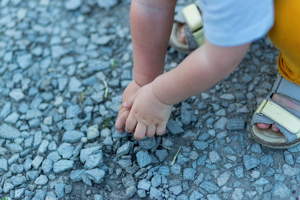 Χέρια ενός μικρού αγοριού γεμάτα μικρές πέτρες. - Φωτογραφία, εικόνα
