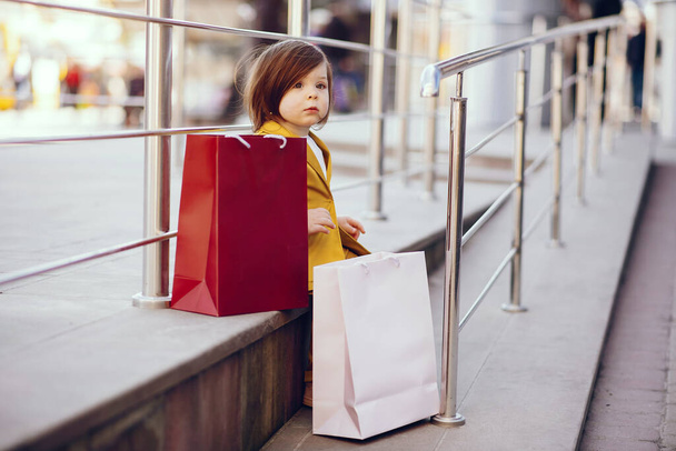 Cute little girl with shopping bag in a city - Fotoğraf, Görsel
