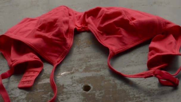 Červená podprsenka na rustikální kovové podlaze. Romantická vášeň ženské spodní prádlo. Sexy módní pozadí. Video záběry zátiší. - Záběry, video