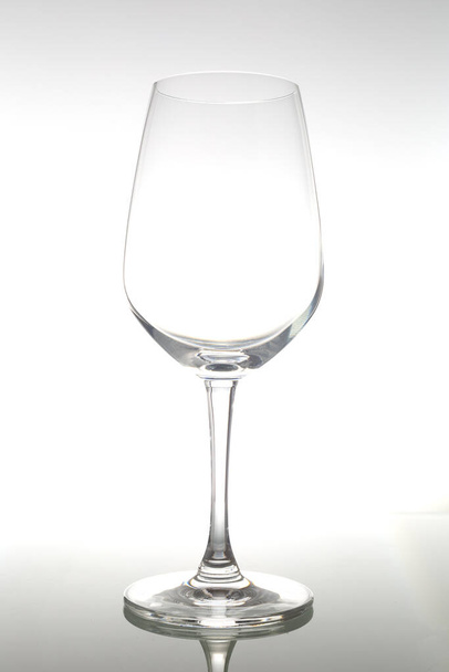 Empty wine glass on glass table. Empty glass on white background. - Photo, Image
