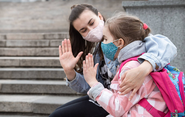 Wracać do szkoły. Dzieci z pandemią koronawirusową chodzą do szkoły w maskach. Przyjazne stosunki z moją matką. - Zdjęcie, obraz