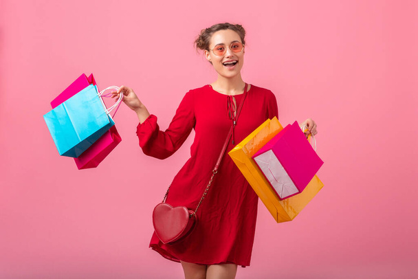 attractive happy funny emotion stylish woman shopaholic in red trendy dress holding colorful shopping bags on pink studio background isolated, sale excited, spring summer fashion trend - Foto, Imagem