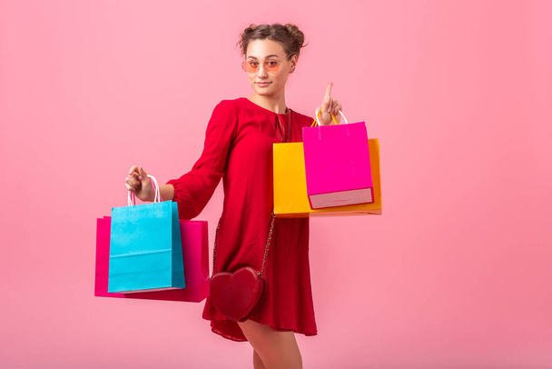 attractive happy funny emotion stylish woman shopaholic in red trendy dress holding colorful shopping bags on pink studio background isolated, sale excited, spring summer fashion trend - Foto, immagini