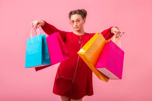 attractive stylish woman with colorful shopping bags on pink background - Fotografie, Obrázek