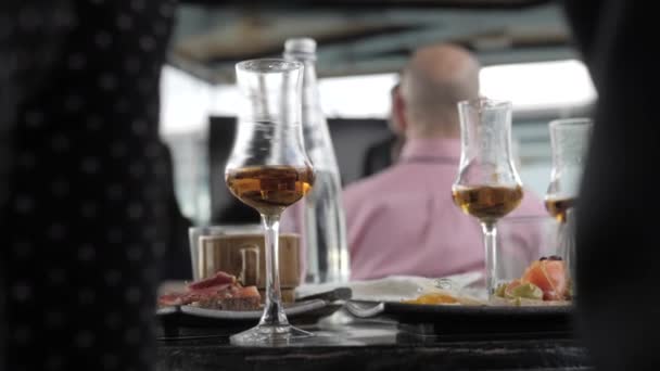 Whiskey in glasses on a thin leg. Cocktail party whiskey tasting. Day - Πλάνα, βίντεο