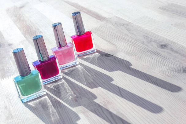 Group of bright nail polishes, bottles lit by the sun - Foto, Imagen