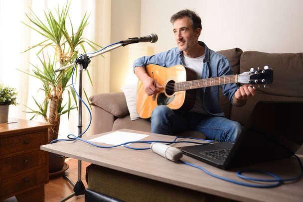 Home recording equipment for music with acoustic guitar, microphone and laptop on wooden table. Top view - Foto, immagini